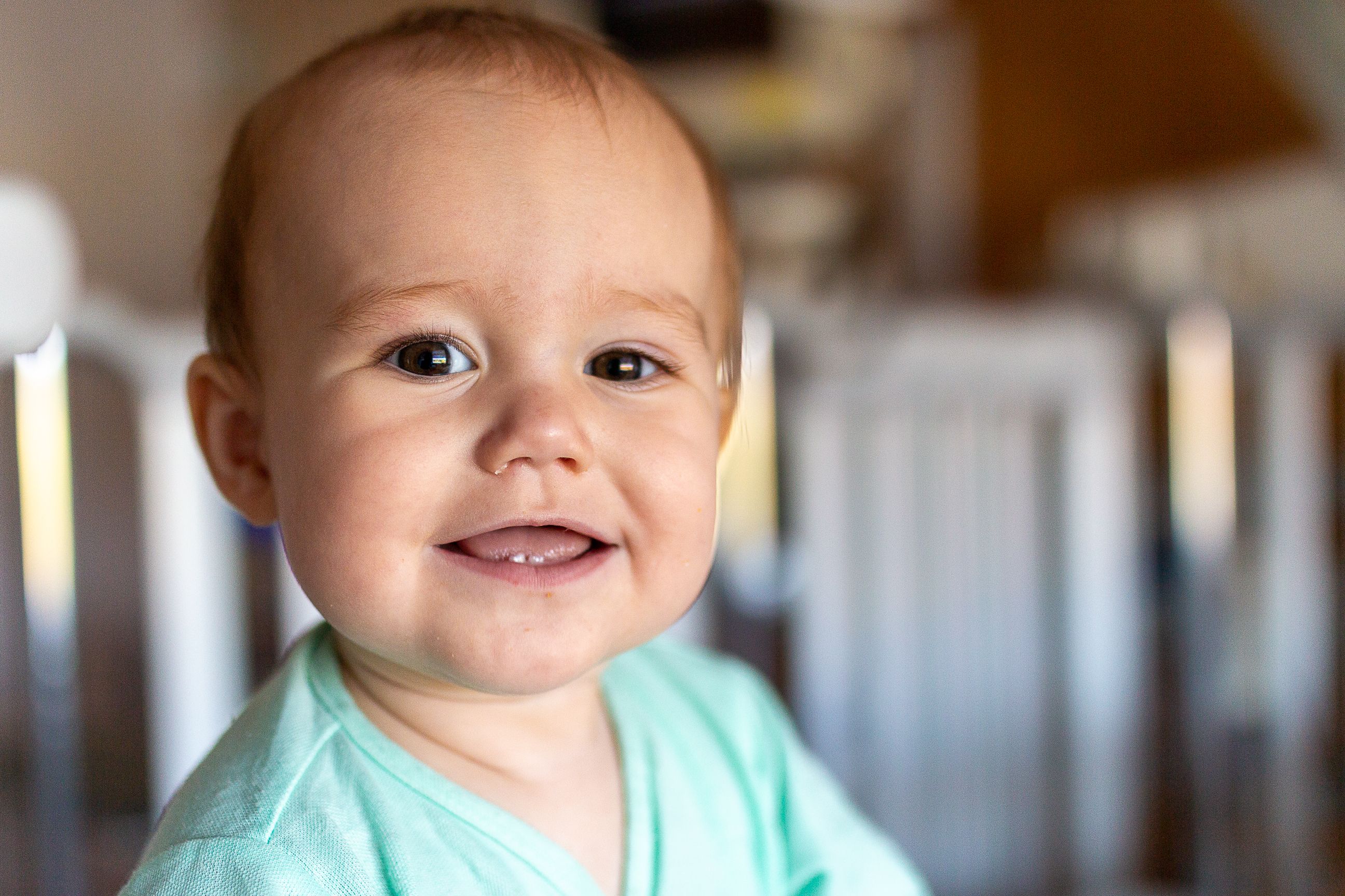 Lachende baby met de eerste doorkomende tandjes in de onderkaak